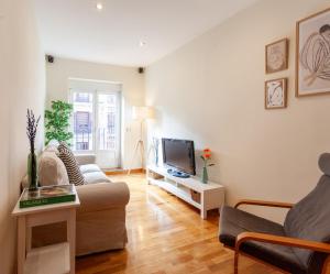 a living room with a couch and a tv at Piso con dos dormitorios frente a Plaza Mayor in Madrid