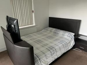 ロンドンにあるImmaculate 1-Bed Apartment in East Londonのベッドルーム(ベッド1台、椅子、テレビ付)