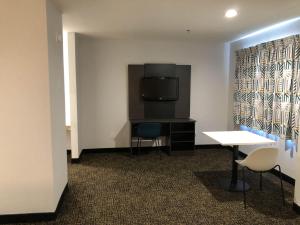 a room with a desk and a television and chairs at Studio 6 Killeen TX in Killeen