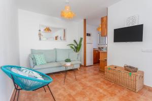 uma sala de estar com um sofá e uma cadeira em Apartamento con patio em Cala Santandria