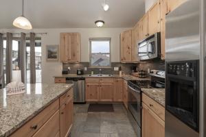 a kitchen with wooden cabinets and granite counter tops at Trailhead Lodges Building 401 Unit 422 in Winter Park
