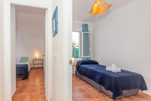 1 dormitorio con 1 cama y 1 habitación con pasillo en Apartamento con patio en Cala Santandria