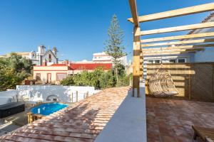 a backyard with a swimming pool and a wooden pergola at Amália Boutique Suites & Studios - by @ rita´s place in Faro