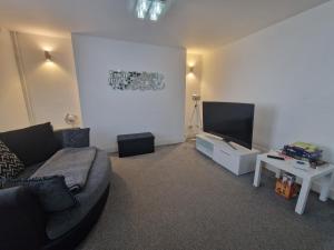 ein Wohnzimmer mit einem Sofa und einem Flachbild-TV in der Unterkunft 3 bedroom modern house. Merthyr Tydfil near bike park wales and Brecon Beacons National park in Dowlais