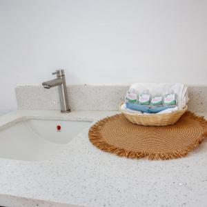 ein Korb mit Handtüchern auf einer Theke neben einem Waschbecken in der Unterkunft Sofy House, San diego, La Libertad in La Libertad