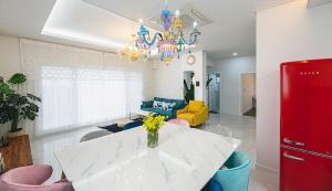 済州市にあるHomechee Kids Poolvillaのリビングルーム(白いテーブル、赤い冷蔵庫付)