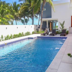 einen Pool mit zwei Stühlen und ein Haus in der Unterkunft Sofy House, San diego, La Libertad in La Libertad