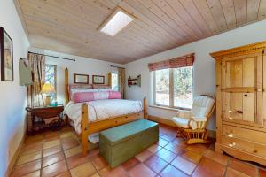 um quarto com uma cama e um tecto de madeira em Pueblo de Canoncito em El Prado