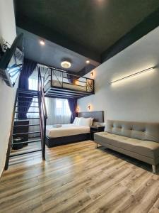 a bedroom with a loft bed and a bed and a couch at Georgetown Inn by Sky Hive in George Town