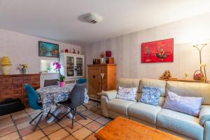 a living room with a couch and a table at Maison mitoyenne proche lac annecy in Annecy-le-Vieux