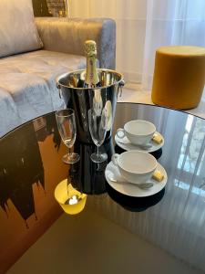 uma mesa de vidro com dois pratos e copos de vinho em Hotel Royal em Praga
