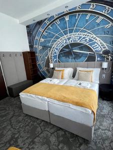 een slaapkamer met een klok muurschildering op de muur bij Hotel Royal in Praag