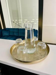 un vassoio con bicchieri e una brocca di vetro su un tavolo di Hotel Royal a Praga