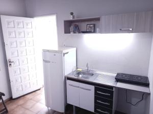 a kitchen with a white refrigerator and a sink at ReGaGe in Florianópolis