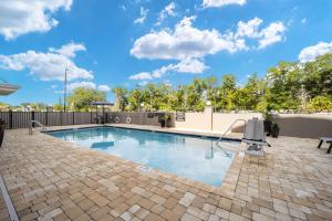 einen Pool mit einer Backsteinterrasse und blauem Himmel in der Unterkunft Candlewood Suites - Ocala I-75, an IHG Hotel in Ocala