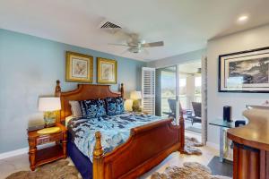 a bedroom with a large bed and a balcony at Tropical Elegance Golf Course Penthouse in Waikoloa +14 photos