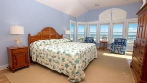 una camera con un letto e alcune finestre e un letto sidx sidx sidx. di OCEANFRONT, Ocean Views, Private Pool, Hot Tub, SS10, The Russell Cottage a Southern Shores Altre 52 foto