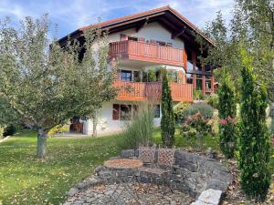 ein Haus mit einem Balkon und einem Garten in der Unterkunft Ferienwohnung Ott in Weißenburg in Bayern