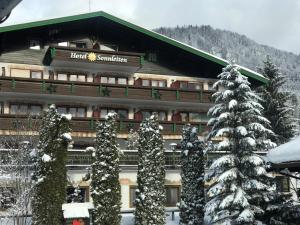 a hotel with snow covered trees in front of a building at Hotel Sonnleiten in Reit im Winkl