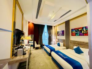 um quarto de hotel com duas camas e uma secretária em فندق لافيرا الرويبح Lavera Hotel em Riyadh