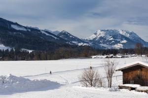a person skiing in a snow covered field with mountains at Hotel Sonnleiten in Reit im Winkl