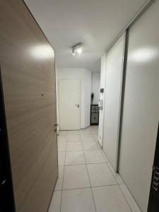 an empty hallway with a door and a tile floor at Appartement de Romain in Annecy