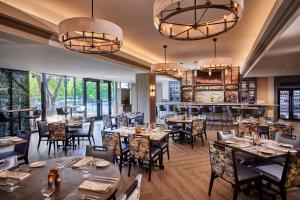 um restaurante com mesas e cadeiras e um bar em The Houstonian Hotel, Club & Spa em Houston