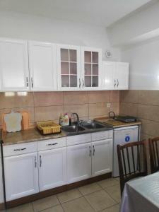 a kitchen with white cabinets and a sink at Vesna Apartment in Ohrid