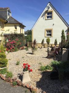 um jardim com flores e plantas em frente a uma casa em The Miners Cottage em Blackwood