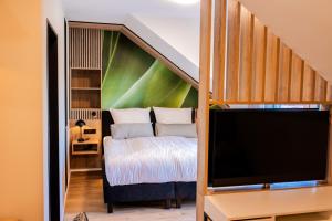 a bedroom with a bed and a flat screen tv at Boardinghouse Hense in Lingen