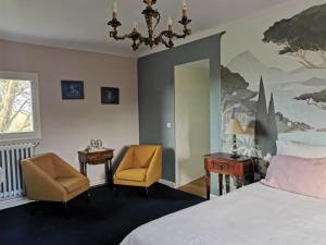 1 dormitorio con 1 cama, 2 sillas y lámpara de araña en Entre Mont St Michel et Merveille, en Vains