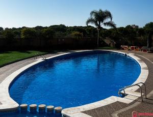 uma grande piscina com água azul num quintal em Rincón de la Naturaleza em Oropesa del Mar