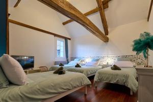 a room with three beds and a tv in it at Maison de Standing - Proche Zoo et centre ville - Parking privé - Le Haut Bois in Saint-Aignan