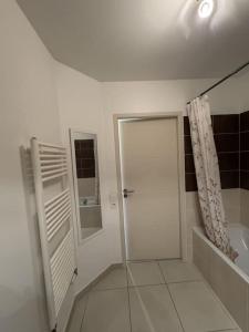 biała łazienka z prysznicem i drzwiami w obiekcie Appartement de Romain w Annecy