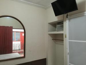 a room with a mirror and a window and a shelf at Hotel Xalapa in Veracruz