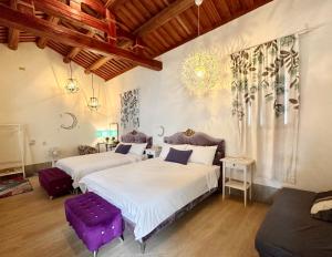 a bedroom with two beds and a purple stool at 依山行館 浪漫恬靜落角處 盡享古厝慢旅時光 in Jincheng
