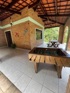 a large patio with a wooden table in front of a building at Casa na serra de mulungu in Mulungu