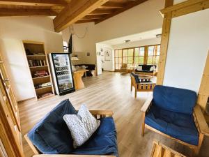 ein Wohnzimmer mit einem blauen Sofa und Stühlen in der Unterkunft Landhotel Maiergschwendt by Deva Hotels & Resorts in Ruhpolding