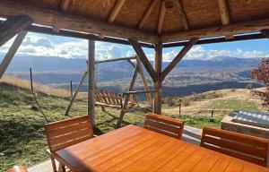 a porch with a wooden table and a swing at Guest House Highland in Pluzine