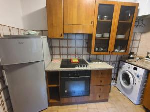 a small kitchen with a stove and a refrigerator at La casa in montagna in Villalago +18 photos