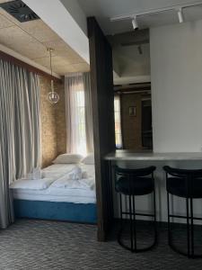 een hotelkamer met een bed en een bar met stoelen bij Hotel Zlatni Bor in Sokolac