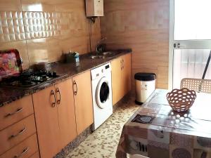 cocina con fregadero y lavadora en Casa vacacional en zona céntrica en Conil, en Conil de la Frontera