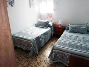 1 dormitorio con 2 camas y ventana en Casa vacacional en zona céntrica en Conil, en Conil de la Frontera