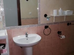 y baño con lavabo y espejo. en Casa vacacional en zona céntrica en Conil, en Conil de la Frontera