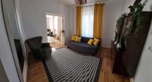 sala de estar con sofá azul y almohadas amarillas en Dom pod Jabłonką, en Tomaszów Lubelski