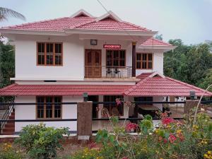 a white house with a red roof at Anna homestay in Chegāt
