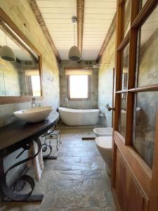a bathroom with two sinks and a tub and two toilets at Chacra La Esencia, casa de campo in El Eden