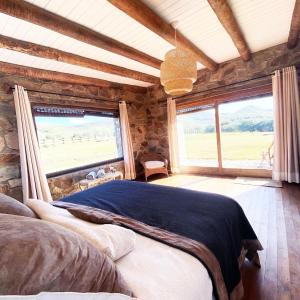 a bedroom with a bed and a large window at Chacra La Esencia, casa de campo in El Eden