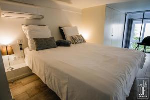 een groot wit bed in een kamer met een raam bij Le loft Cannes in Cannes