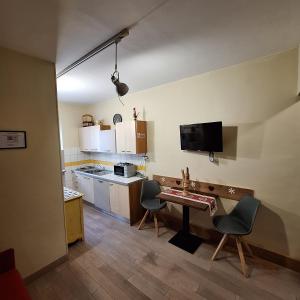 a kitchen with a table and chairs in a room at Monolocale piccolo ed accogliente - CIR 0021 - in Aosta